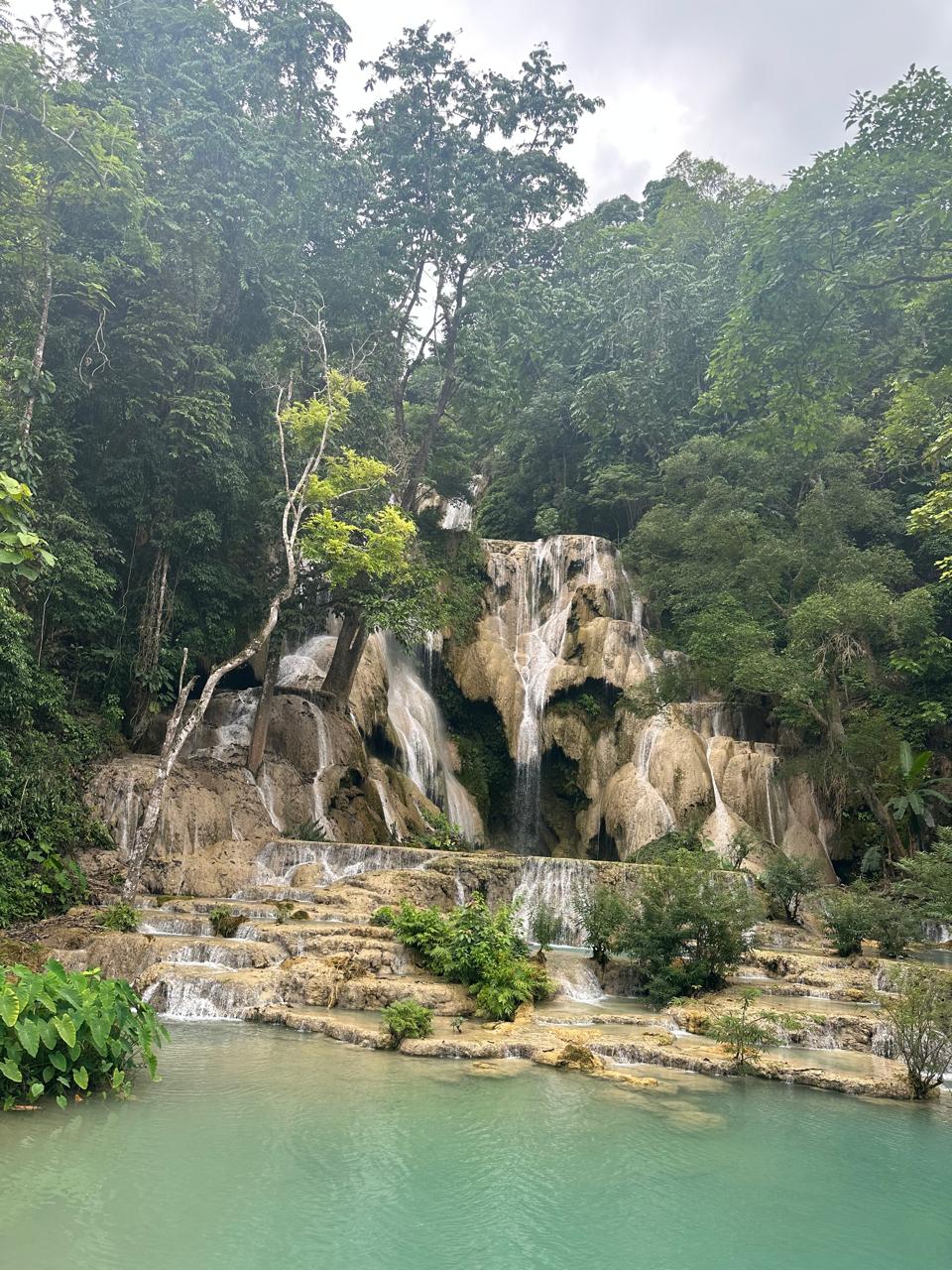 Turquoise pools beneath a jungle waterfall in Southeast Asia